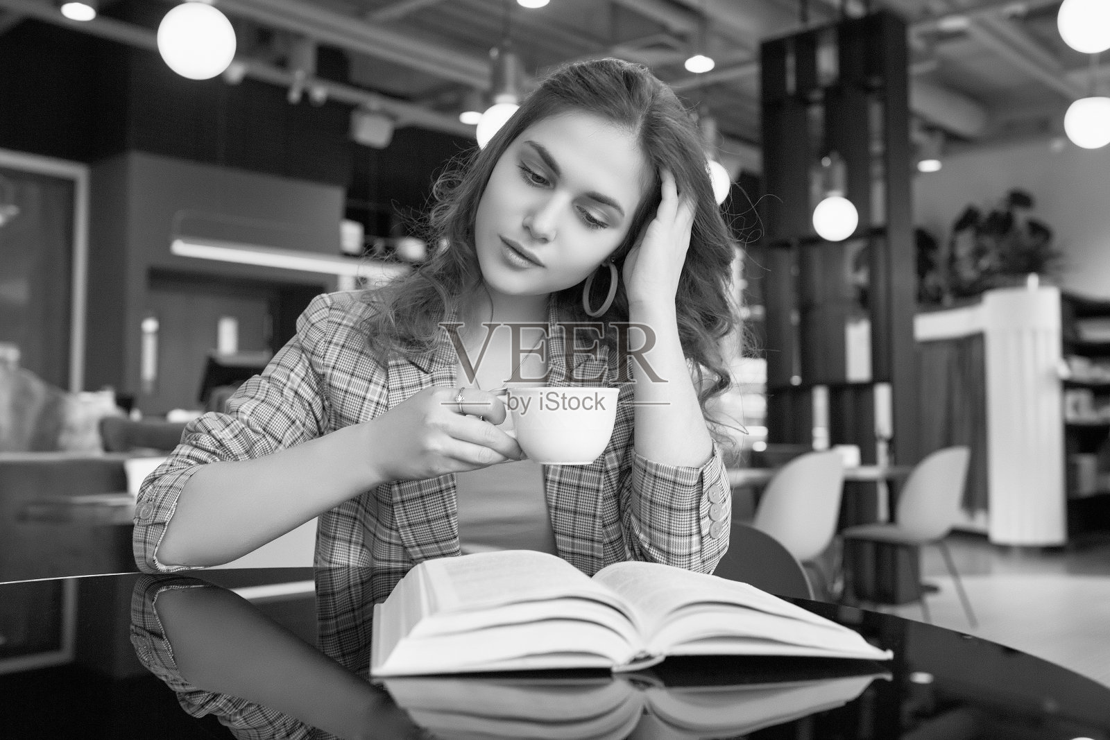 年轻漂亮的女人在咖啡馆喝咖啡和看书照片摄影图片