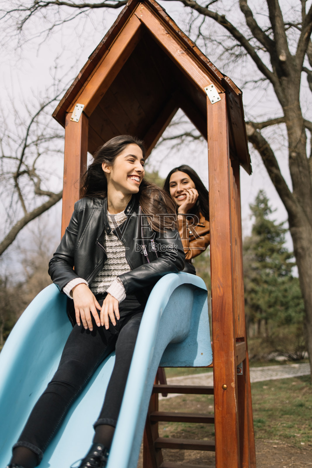 姐妹们在公园里的滑梯上玩耍照片摄影图片