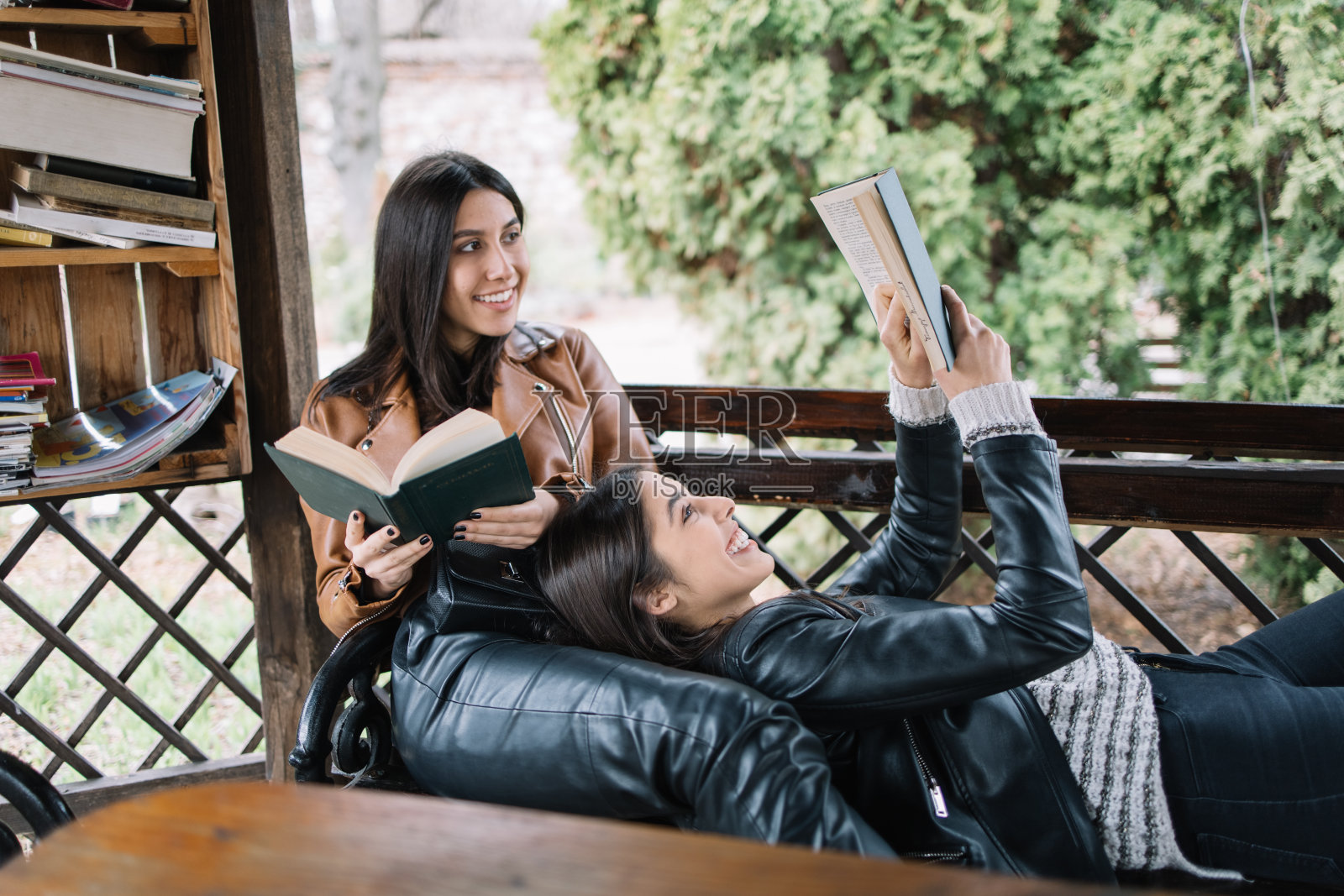 年轻女子躺在凉亭里看书照片摄影图片