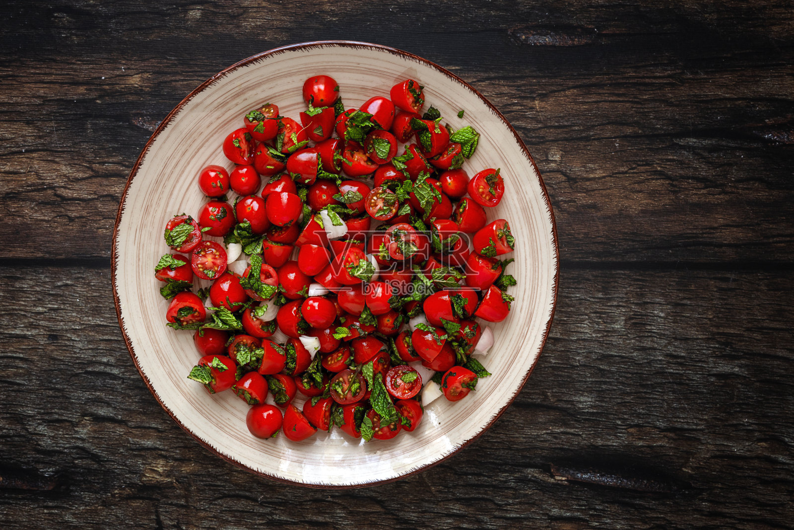 自制樱桃番茄沙拉，加入新鲜洋葱，薄荷，橄榄油和盐照片摄影图片