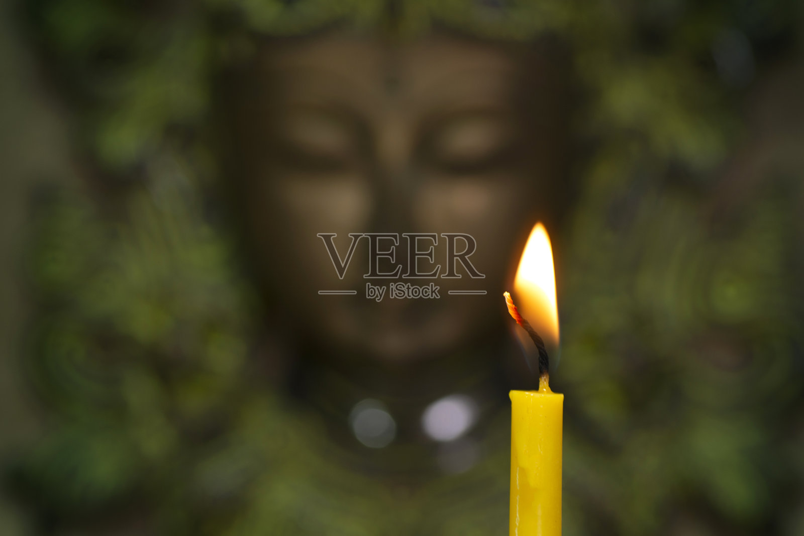 在佛像前的寺庙内，蜡烛上的火焰。照片摄影图片