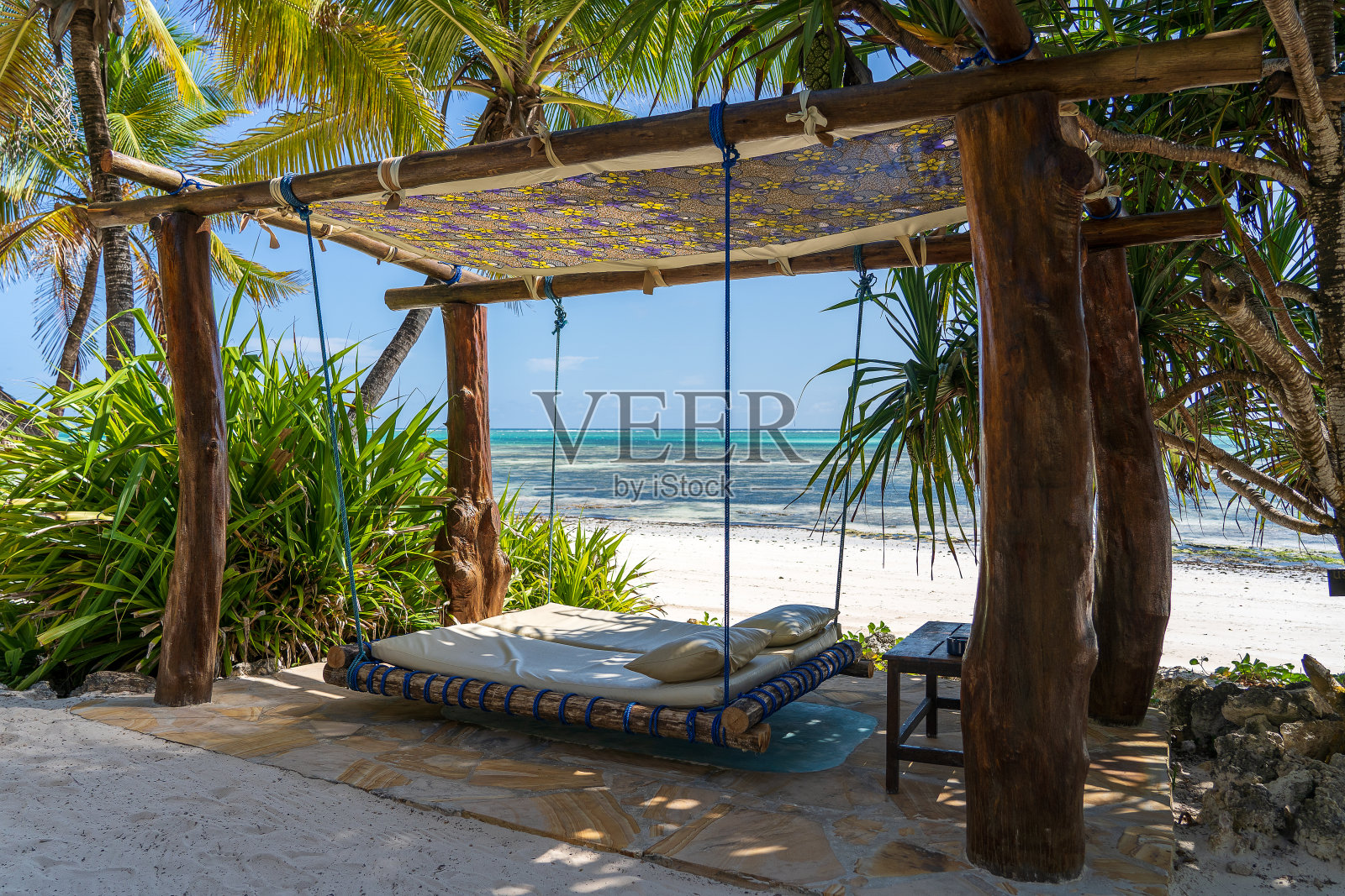 东非坦桑尼亚桑给巴尔岛附近海边的热带海滩上，一个带床垫和枕头的木制秋千照片摄影图片