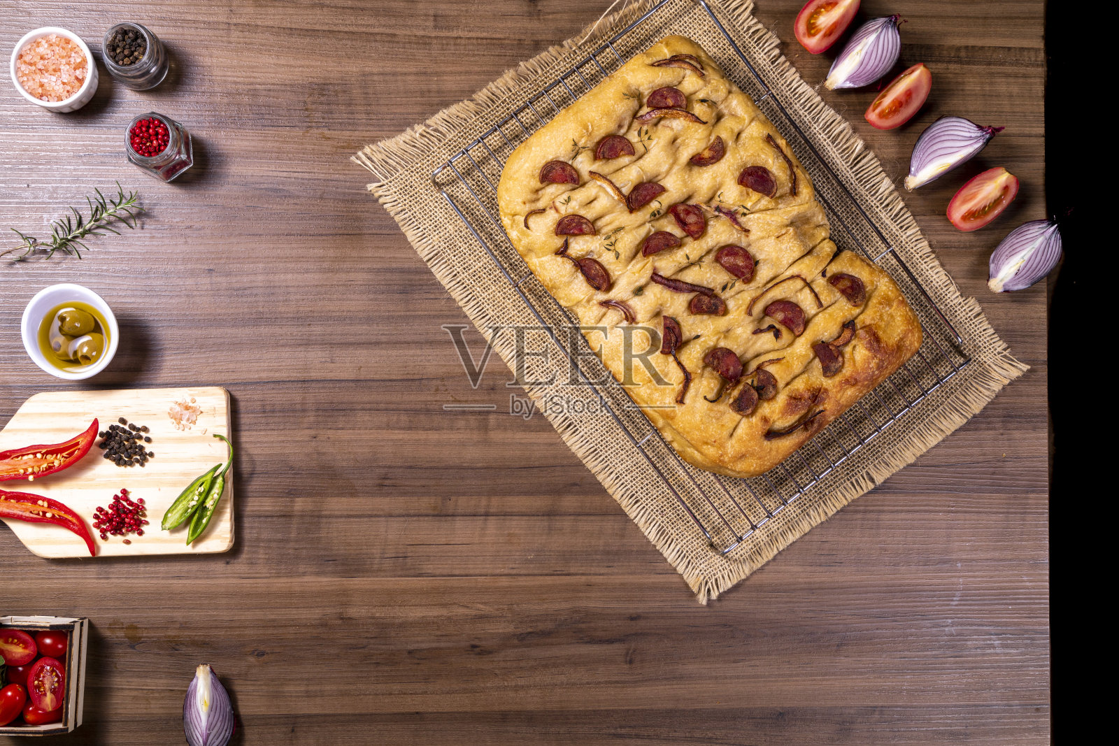 传统的意大利佛卡夏配上意大利辣香肠、樱桃番茄、黑橄榄、迷迭香和洋葱——自制的佛卡夏扁平面包照片摄影图片