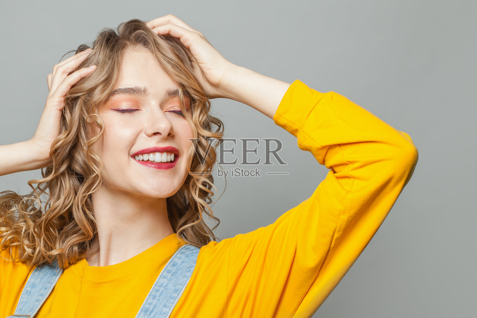 漂亮的女人时装模特微笑在灰色的背景照片摄影图片