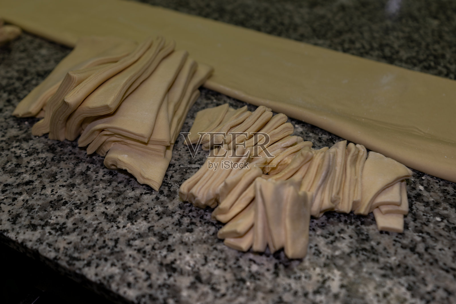 在面包房做成大、小羊角面包之前先揉成三角形照片摄影图片