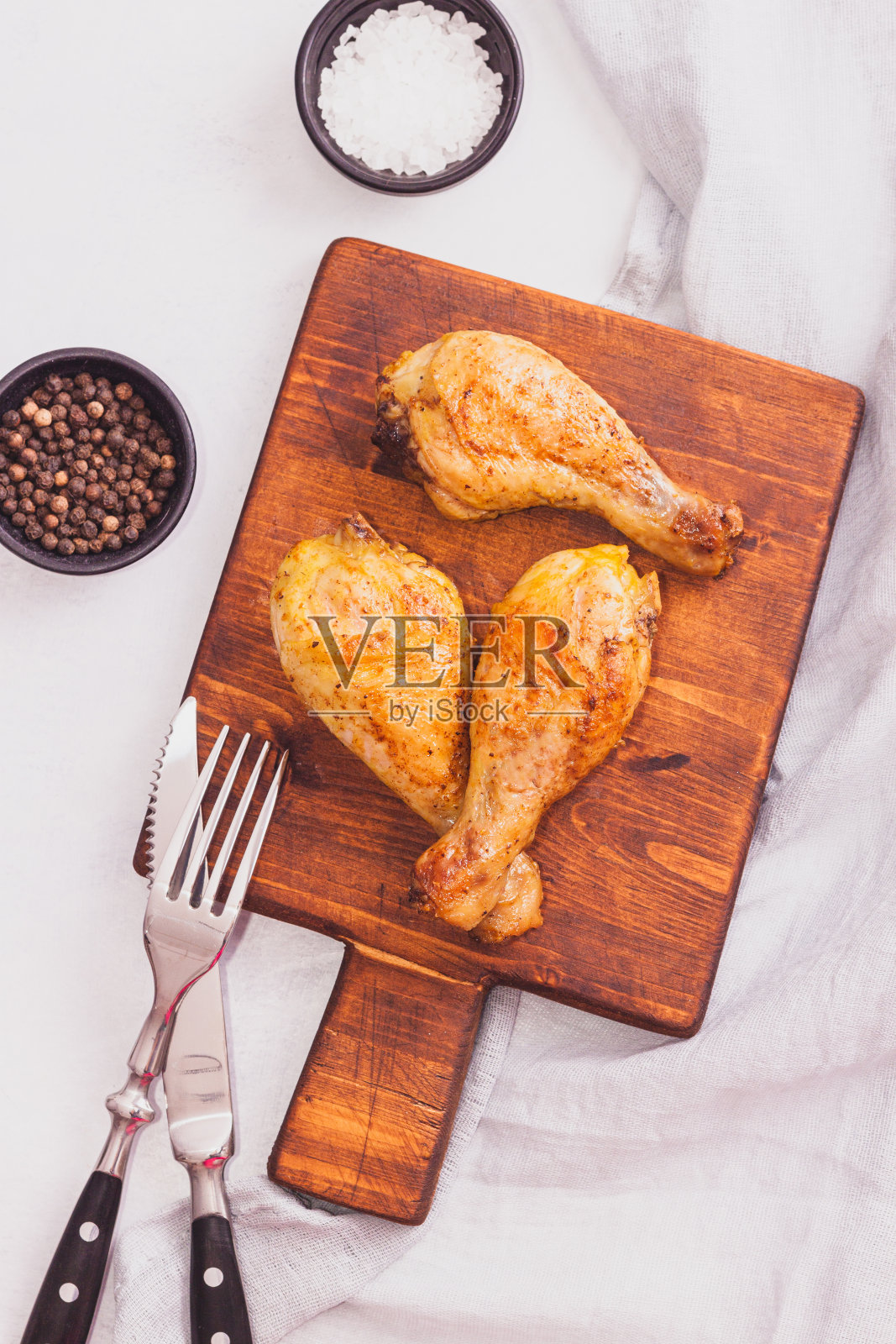 鸡腿酥脆，大腿木砧板与香料桌上照片摄影图片