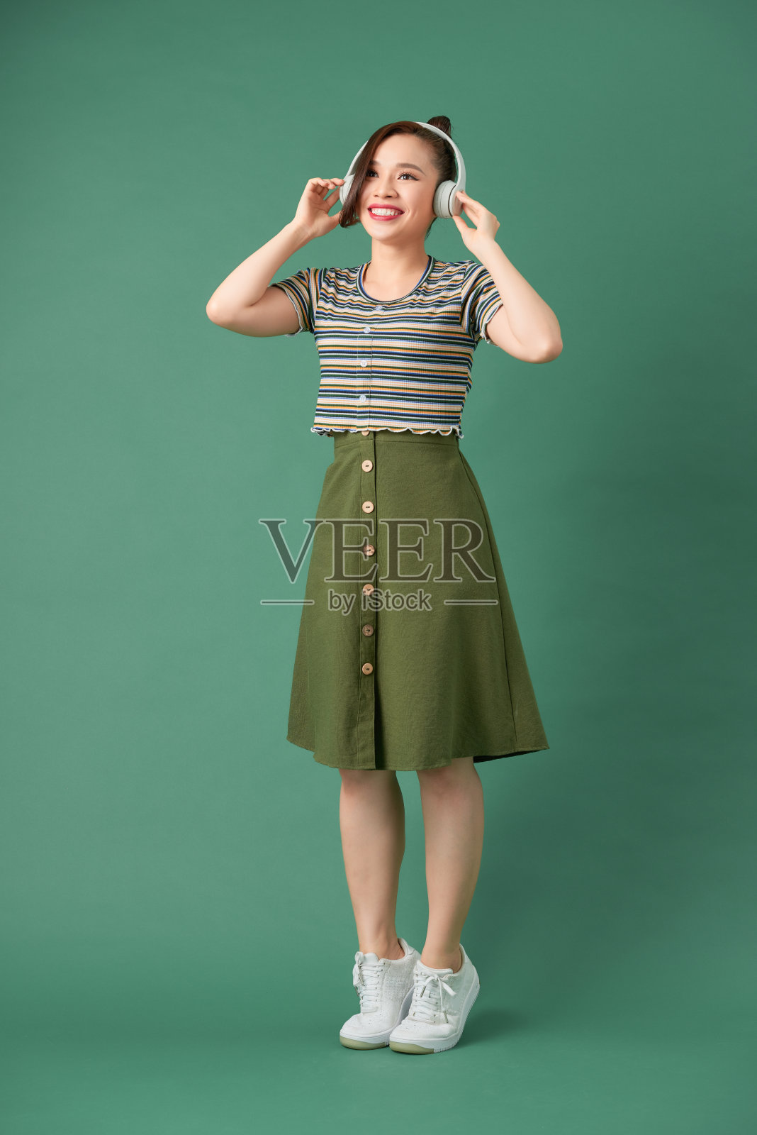 年轻女子戴着耳机听音乐照片摄影图片