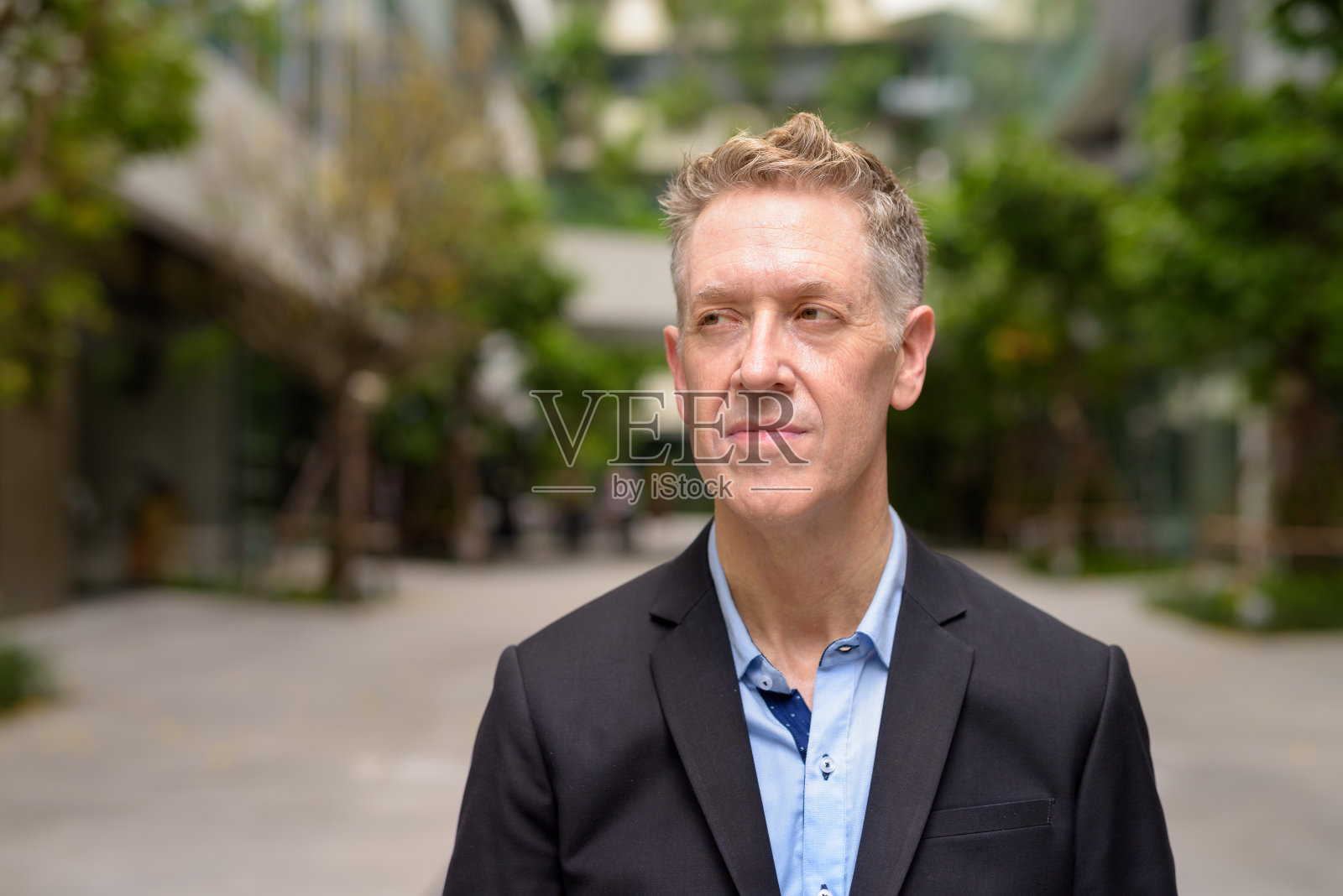 成熟的商人西装革履，思考着城市的自然照片摄影图片