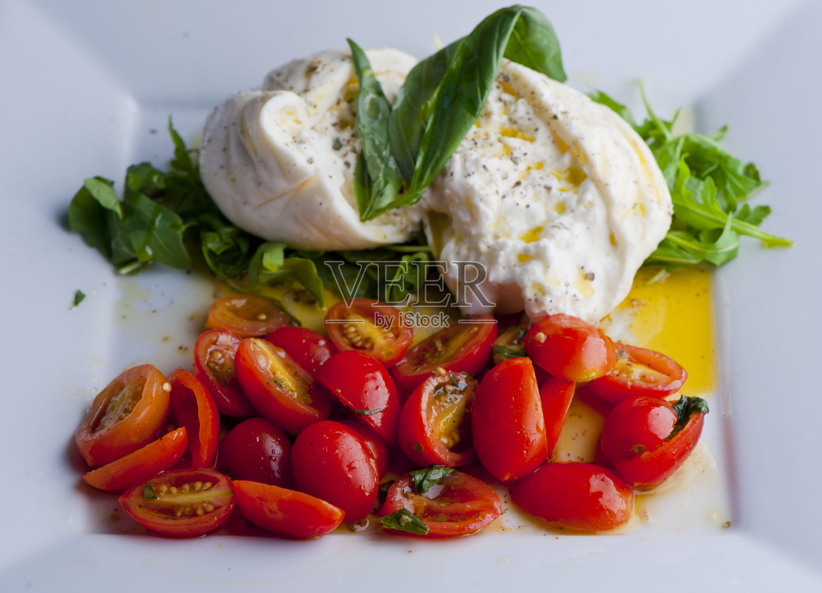 开胃菜盘。经典的意大利开胃菜与樱桃传世番茄，橄榄，朝鲜蓟心，意大利腊肠，水牛奶酪，布里干酪，腌制烤蔬菜，烤面包。照片摄影图片