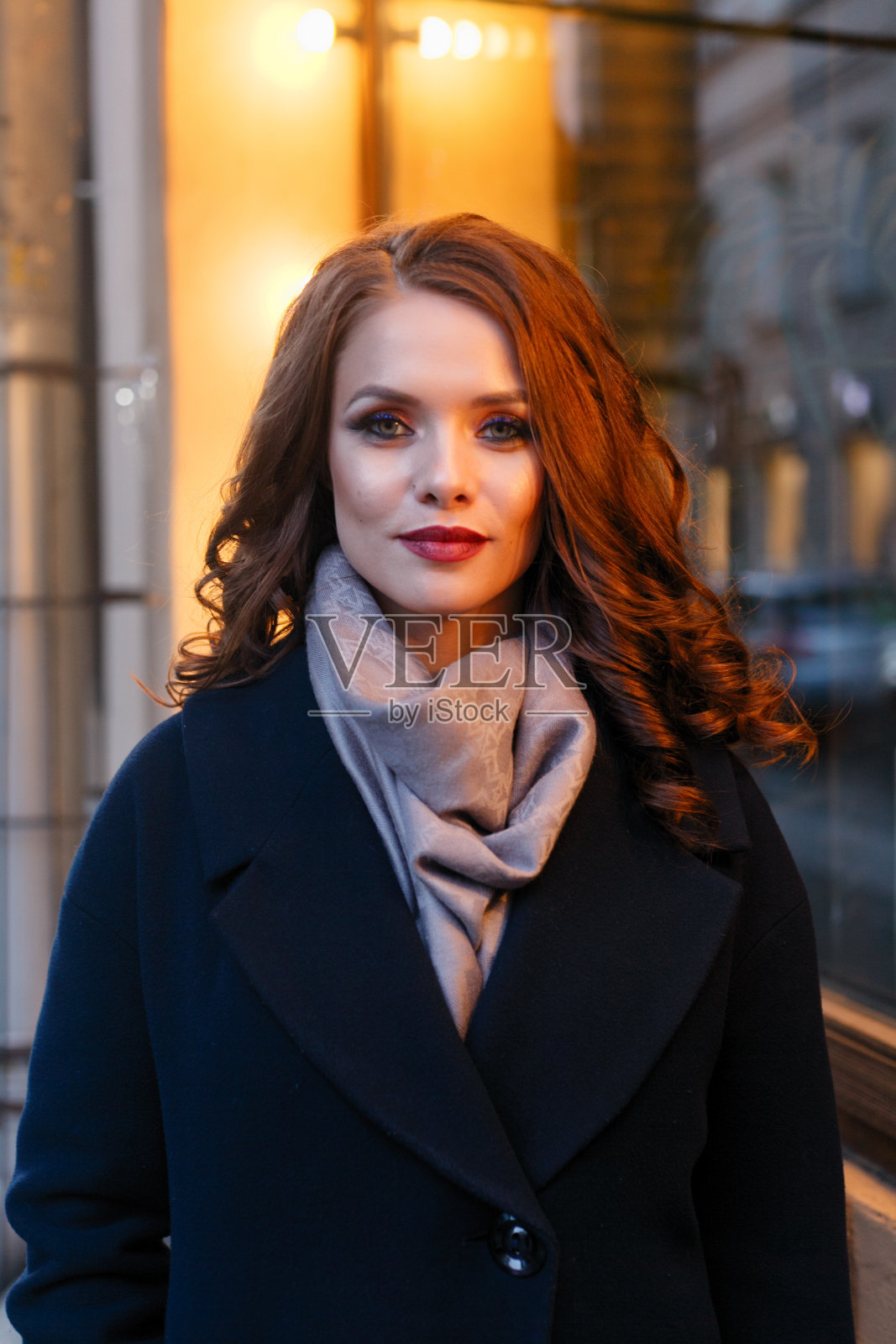 热情微笑的女孩带着闪亮的卷发在城市摆姿势照片摄影图片