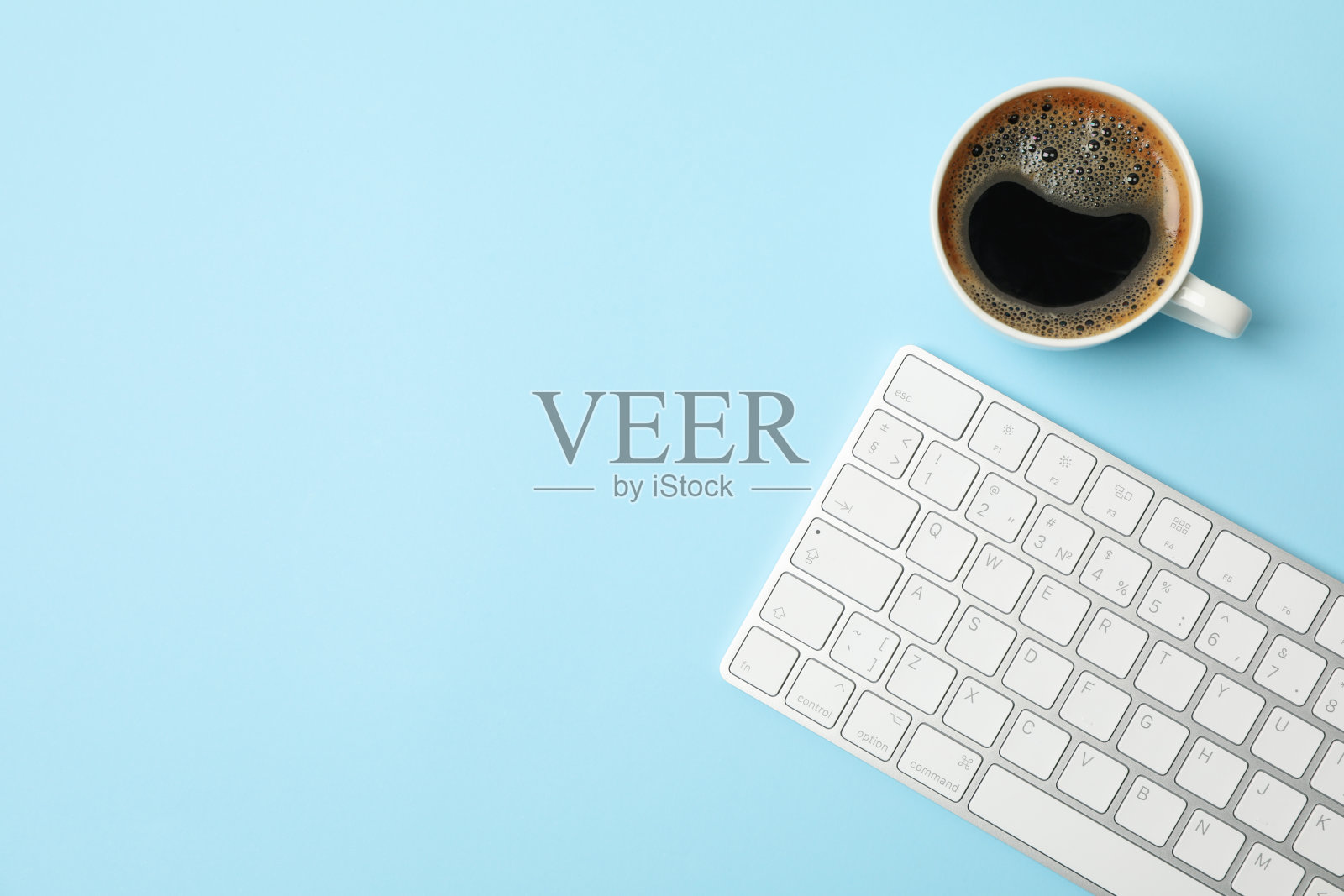 白色键盘和蓝色背景的咖啡，俯视图照片摄影图片