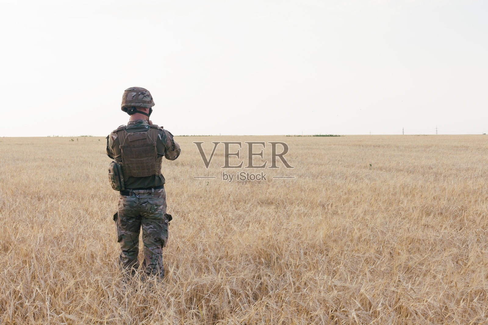 站在田地旁边的士兵照片摄影图片