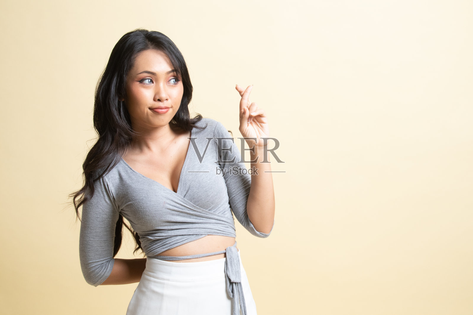 美丽的年轻亚洲女人交叉手指。照片摄影图片