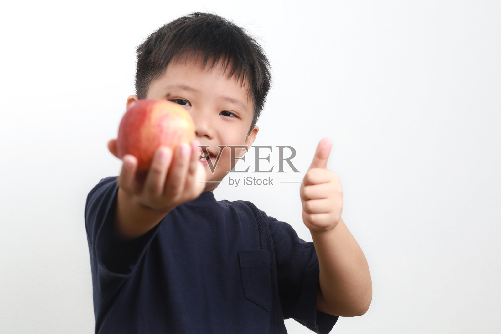 男孩在白色背景下吃苹果照片摄影图片