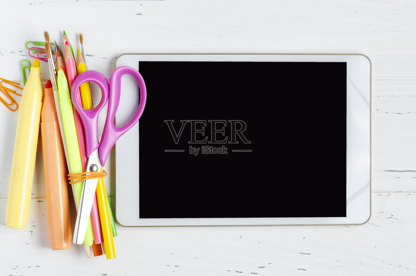 空白屏幕的平板电脑，白色木质背景上放着办公用品。概念应用为学校的孩子或在线学习的孩子。本空间照片摄影图片