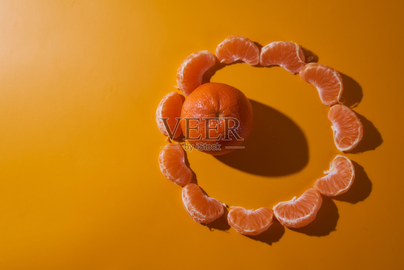 一整只橘子，上面有很多片，背景是橙色。概念图。俯视图照片摄影图片