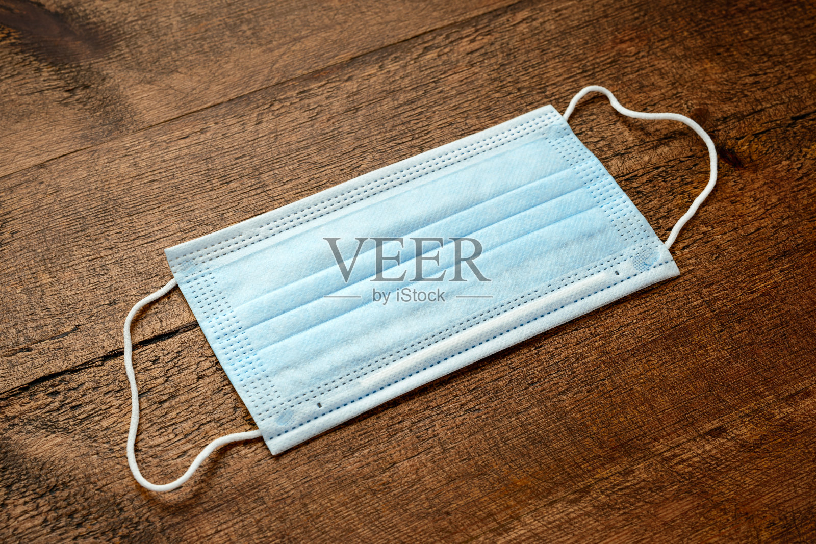 冠状病毒COVID-19大流行。防毒手术防护医用口罩，以木制为背景，防止疾病照片摄影图片