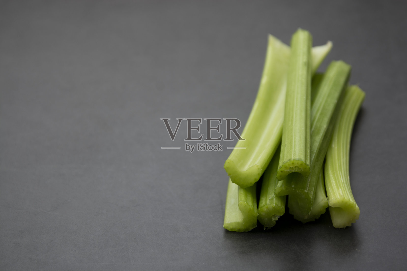 灰色背景上的新鲜芹菜杆。健康食品。副本的空间。照片摄影图片