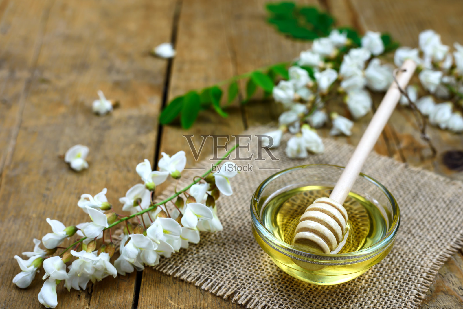 木质背景上的金合欢蜂蜜照片摄影图片