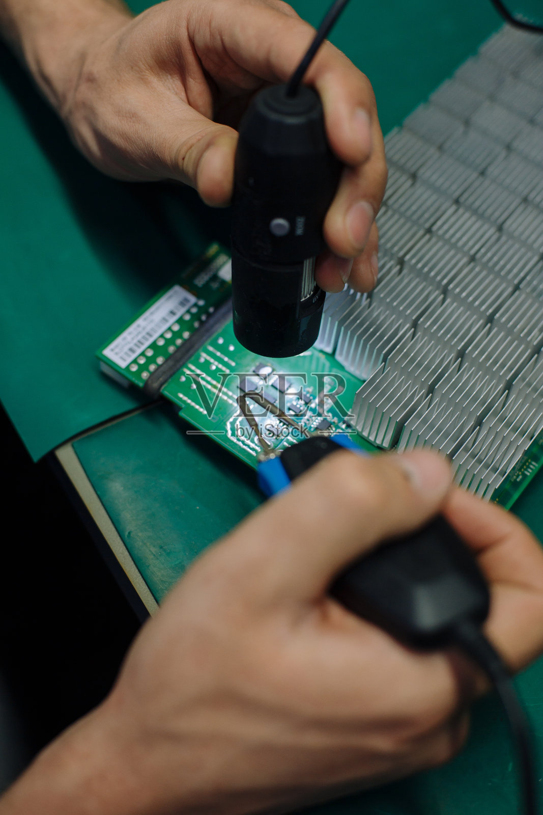 在服务中心修理电脑零件的年轻人。实验室维修和修理服务。电子维修服务理念。用于创建和挖掘比特币的采矿农场的设备照片摄影图片