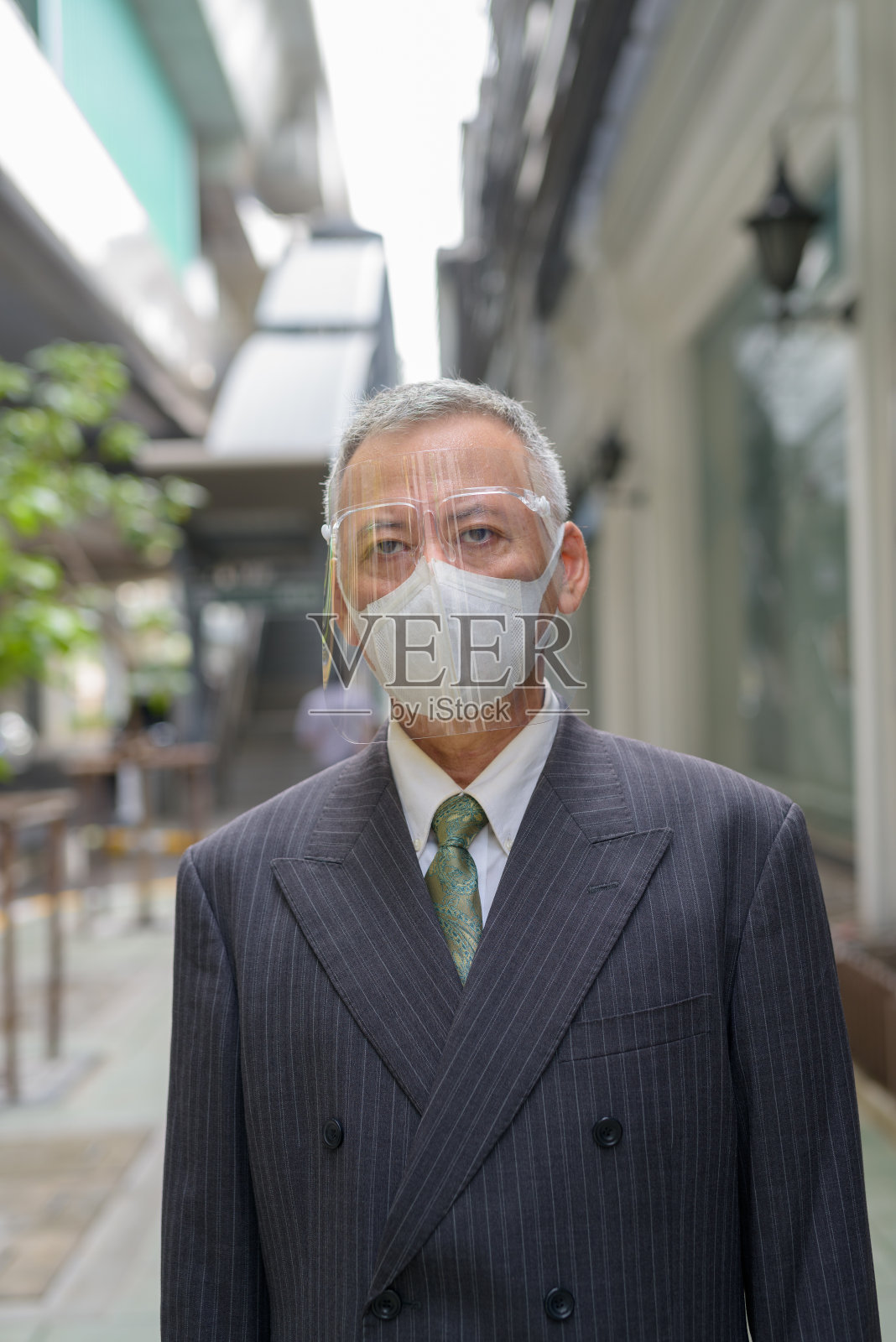 成熟的日本商人在城市里戴着面具和面罩照片摄影图片