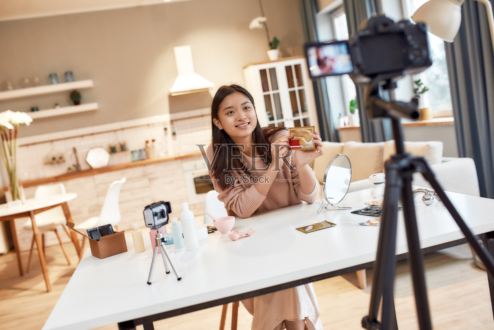 火花,启动起来。年轻的女博主为她的美容博客录制了一段关于护肤程序的教程视频。视频博主展示眼罩，为社交网络录制视频照片摄影图片