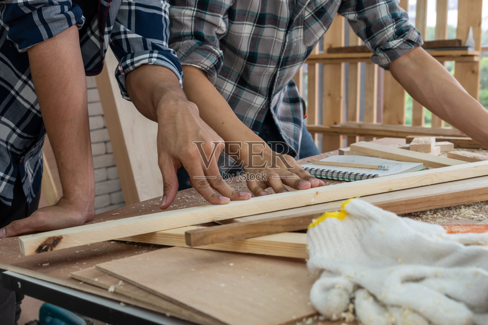 木工在车间从事木材工艺生产建筑材料或木制家具的木匠。这位年轻的亚洲木匠使用专业工具制作工艺品。DIY工匠和木工概念。照片摄影图片