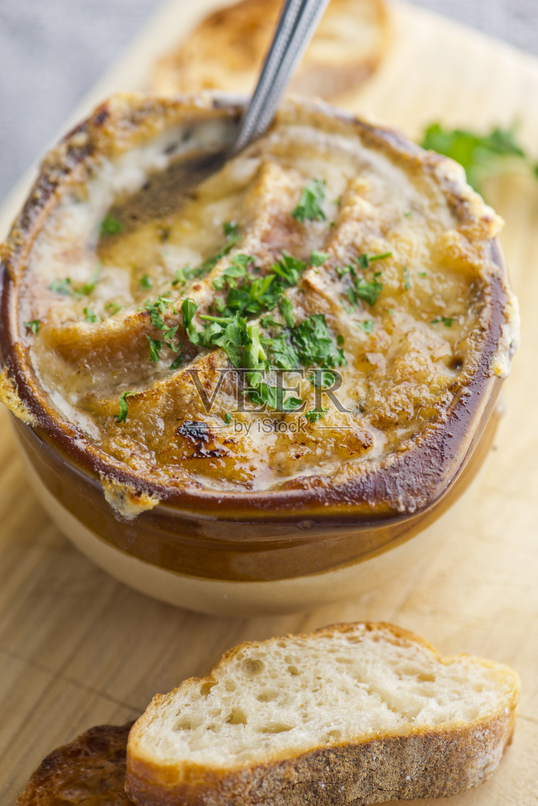 法式洋葱汤。经典的法国或美国餐厅或用餐者的最爱。牛肉汤，洋葱，蔬菜丁，芹菜，胡萝卜，洋葱，大蒜，sautéed在橄榄油和慢煮。顶部浇上融化的奶酪，配上烤面包。照片摄影图片