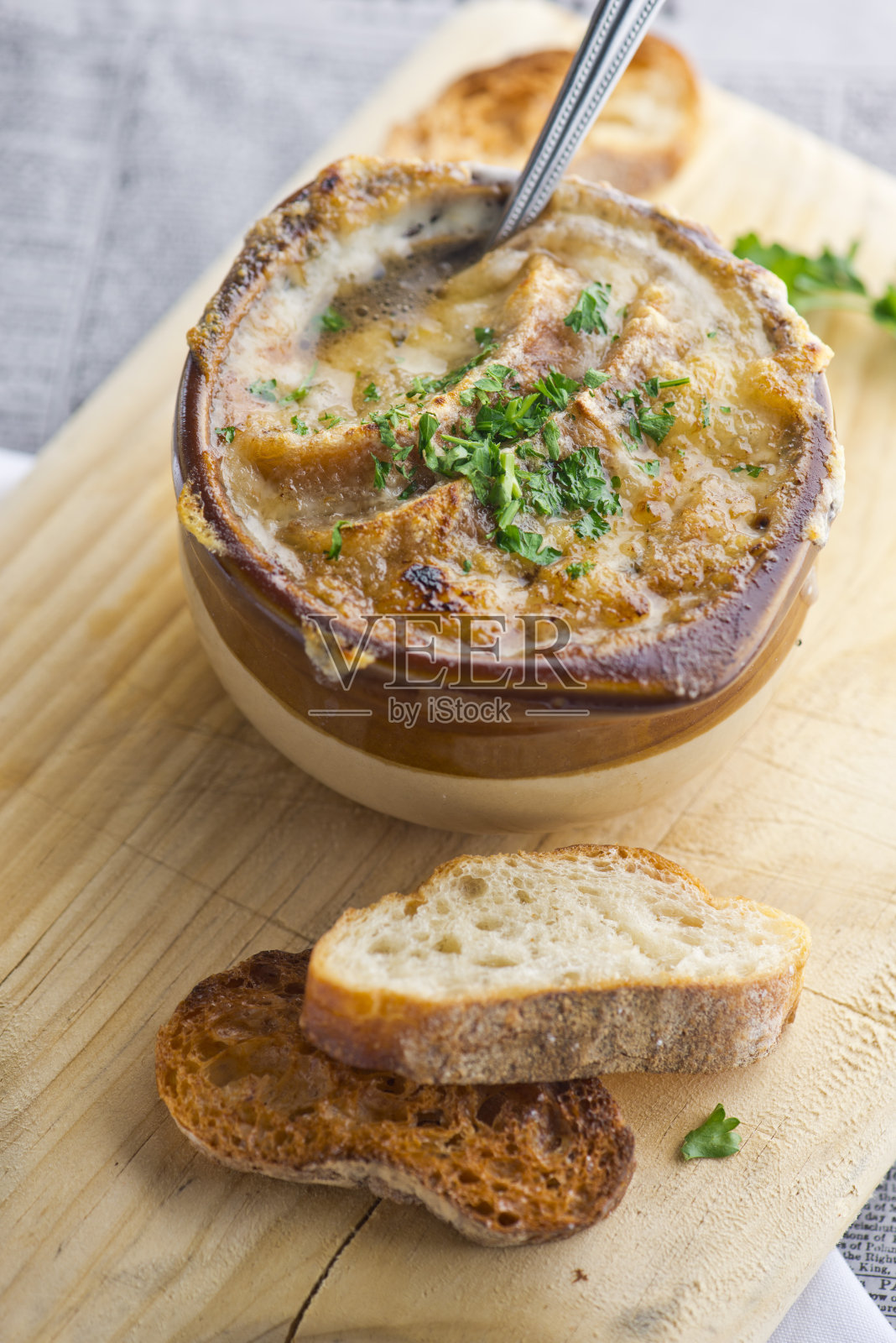 法式洋葱汤。经典的法国或美国餐厅或用餐者的最爱。牛肉汤，洋葱，蔬菜丁，芹菜，胡萝卜，洋葱，大蒜，sautéed在橄榄油和慢煮。顶部浇上融化的奶酪，配上烤面包。照片摄影图片