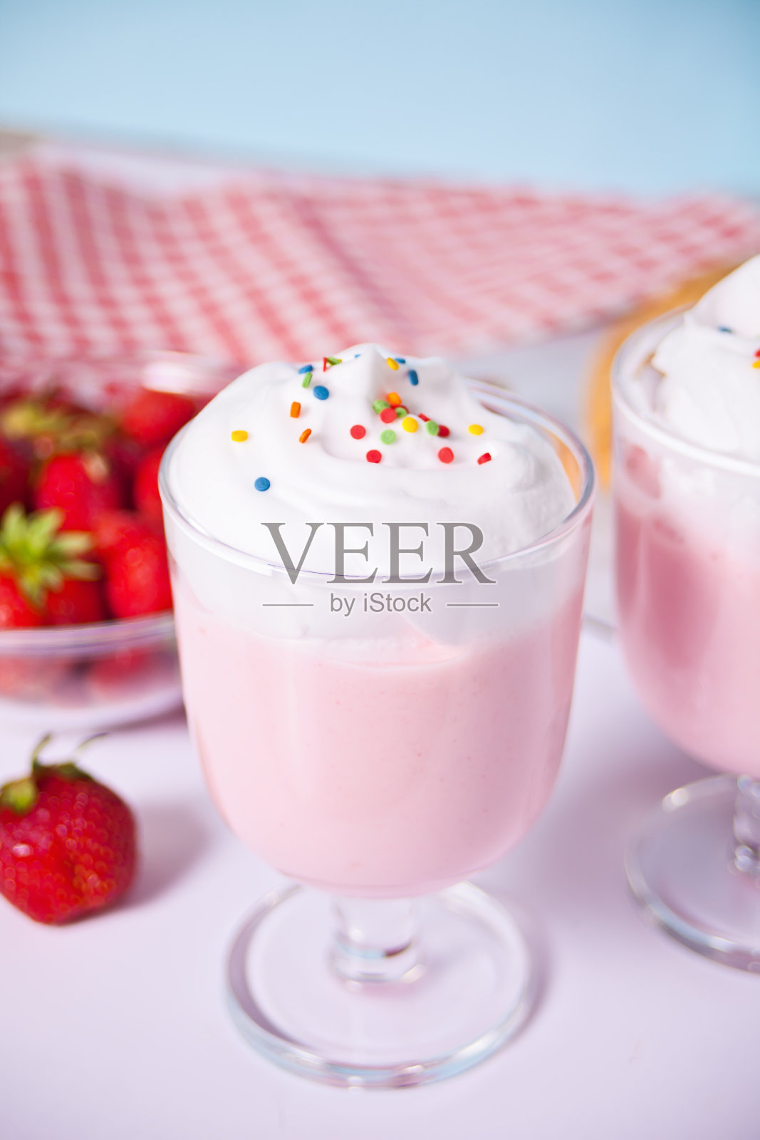 草莓奶昔，奶昔鸡尾酒，加上鲜奶油。照片摄影图片