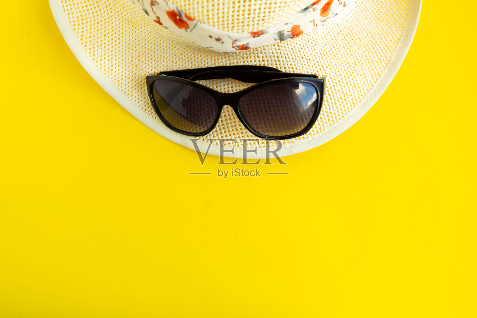 草帽和太阳镜在明亮的黄色背景，俯视图拷贝空间。暑假的概念。最小的概念照片摄影图片