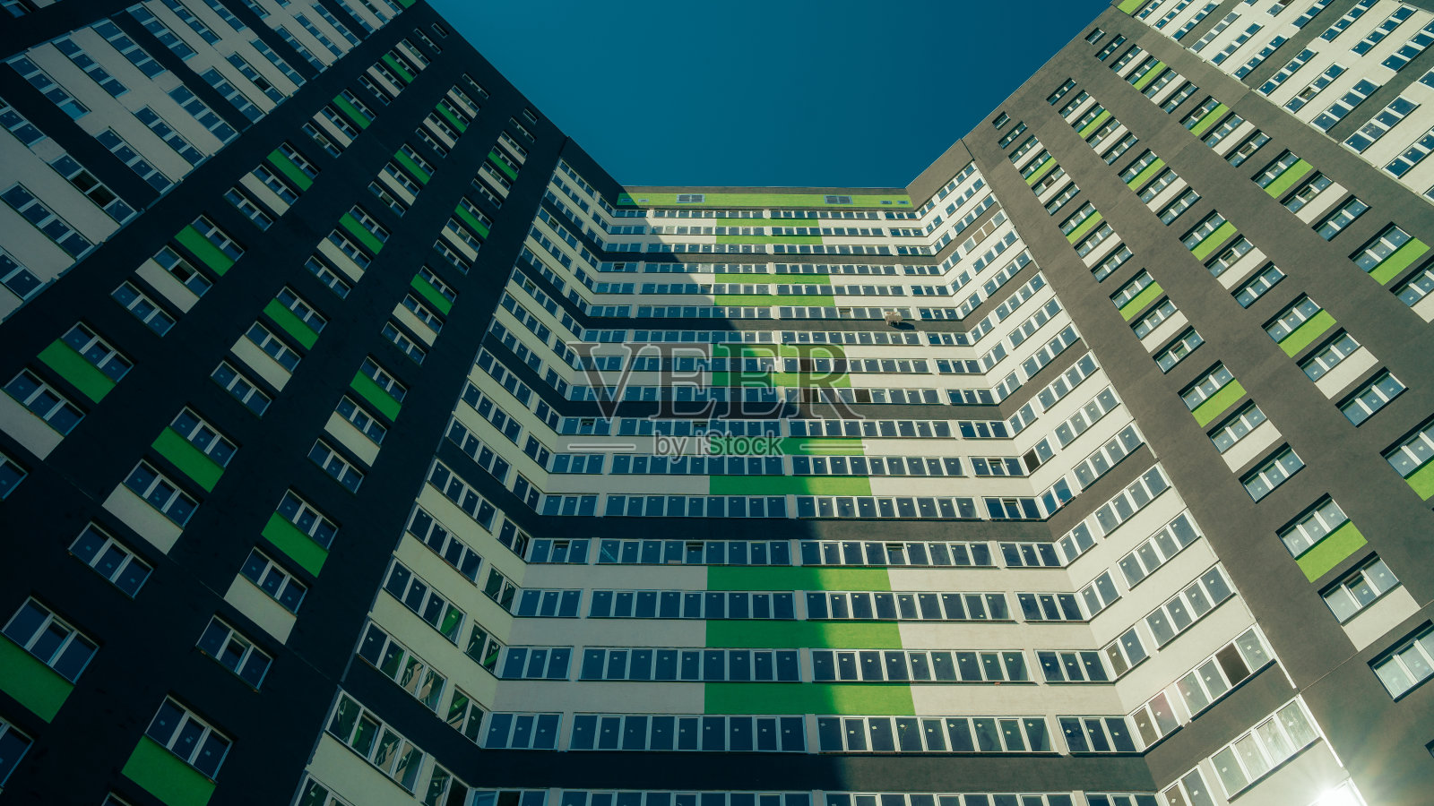 现代化的公寓大楼在一个晴朗的日子与蓝天。现代公寓楼的立面。住宅建筑是现代公寓共管建筑照片摄影图片