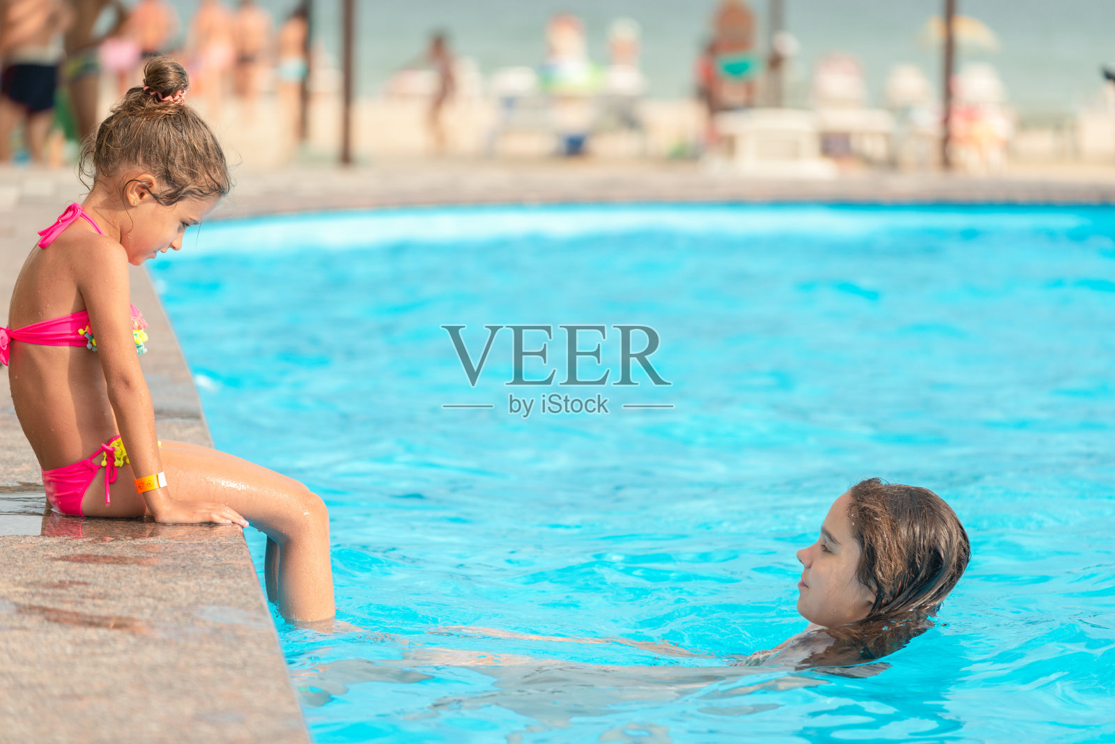 侧视图小女孩姐妹们在游泳池游泳照片摄影图片