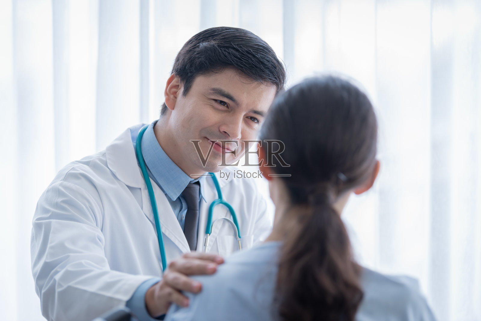 在医院或诊所照顾女病人的医生。照片摄影图片