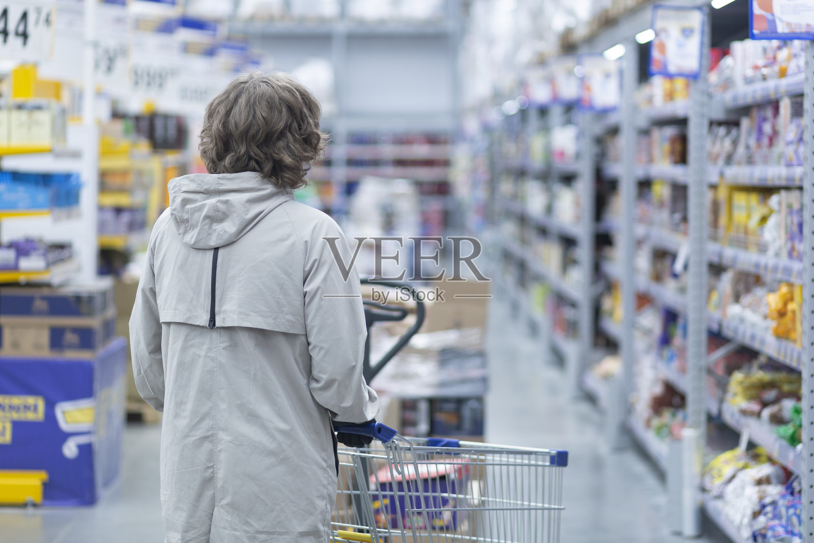 一个男人在超市里拿着一个带医用口罩的篮子照片摄影图片