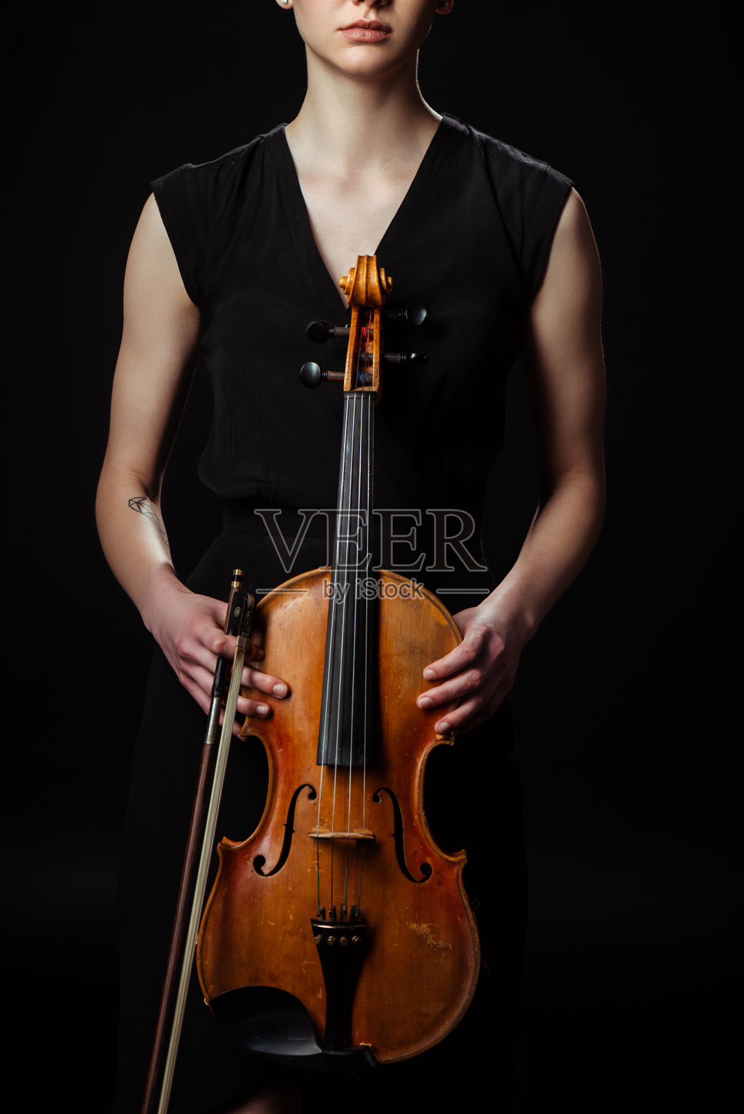女性音乐家抱着古典小提琴孤立在黑色裁剪的观点照片摄影图片