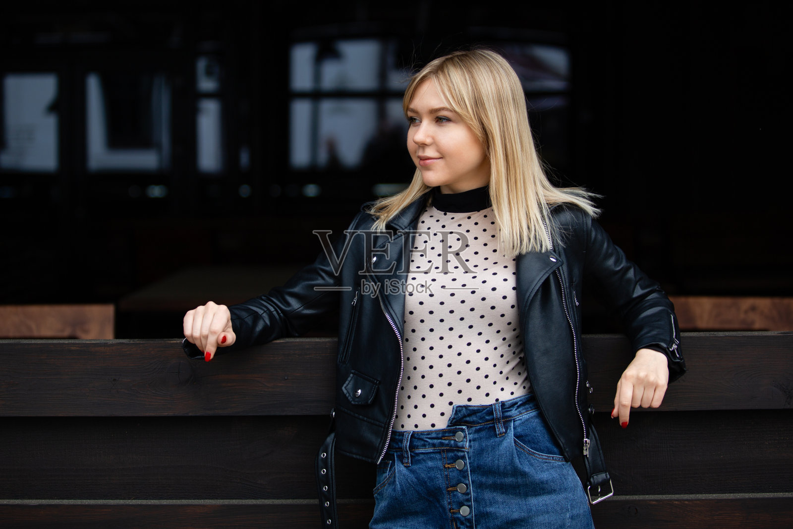 户外生活方式肖像幸福迷人的金发女孩在黑夹克。照片摄影图片