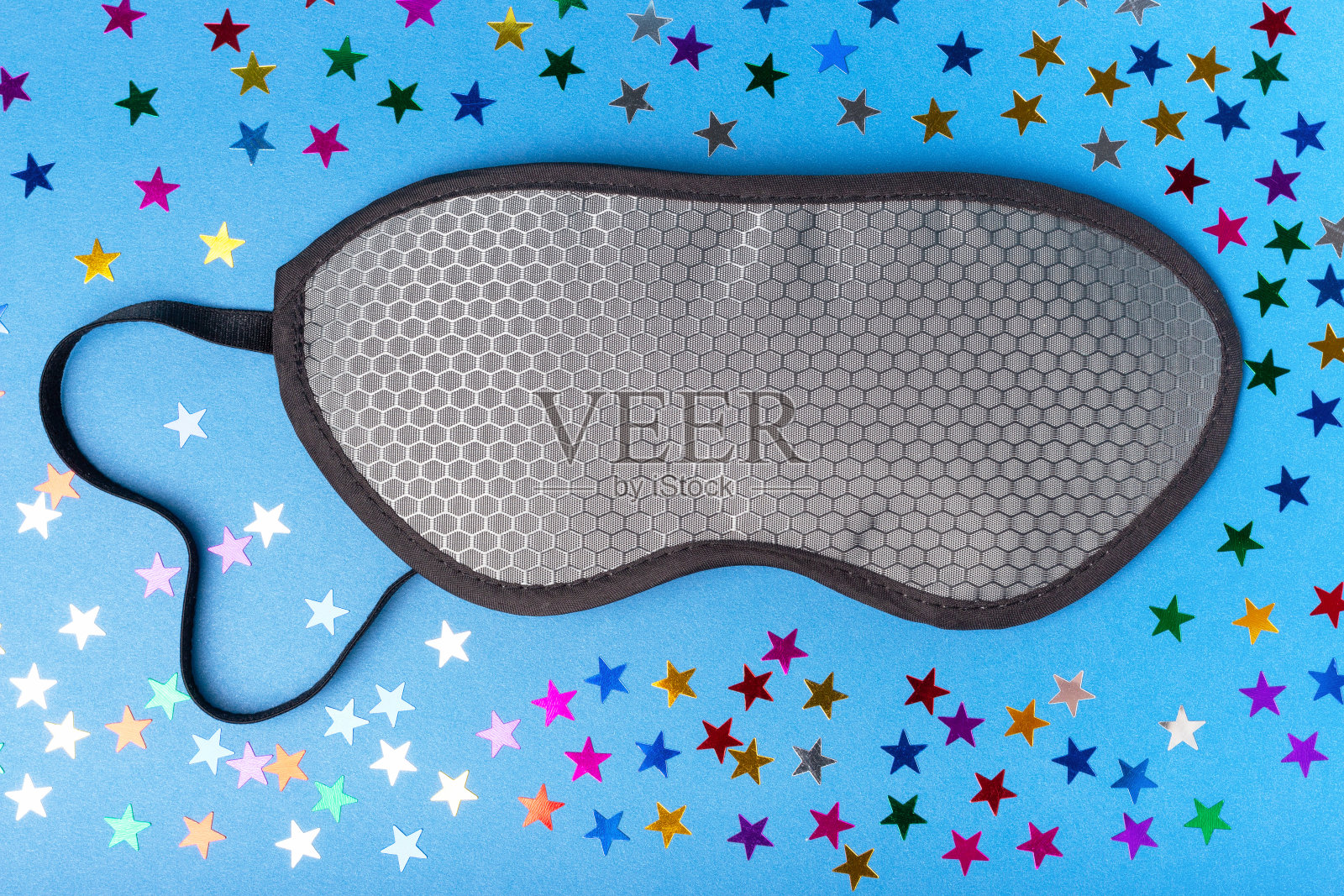 灰色睡眠面具在蓝色背景与星星，从上面看照片摄影图片