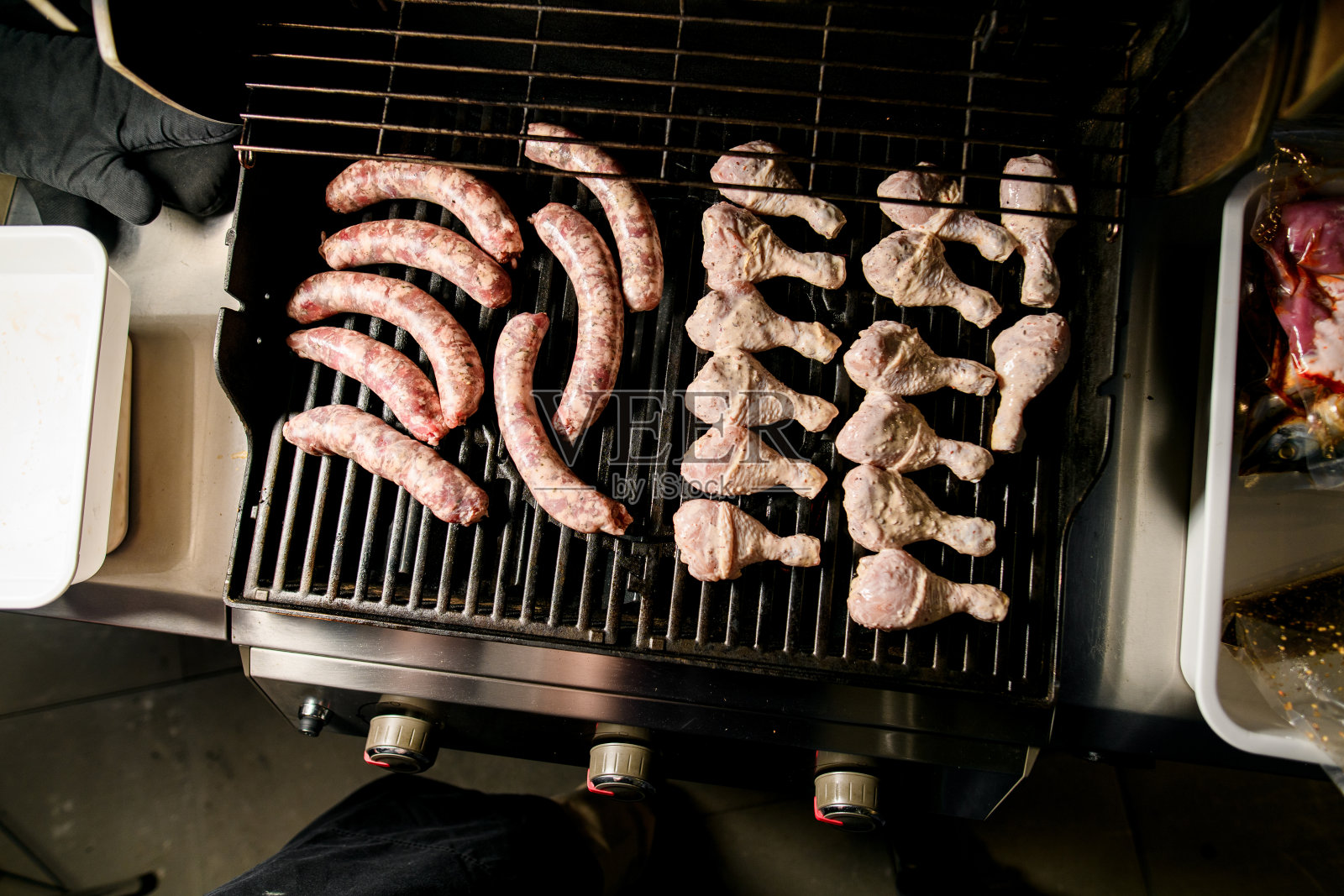 腌过的鸡腿肉和烤肉香肠放在烤架上照片摄影图片