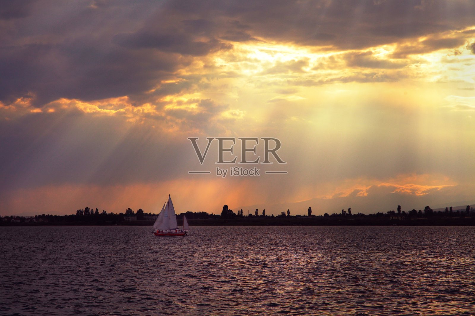 一艘白色轮船驶离海岸。吉尔吉斯斯坦的山脉。大海里蓝色的水。天空中美丽的云彩。照片摄影图片