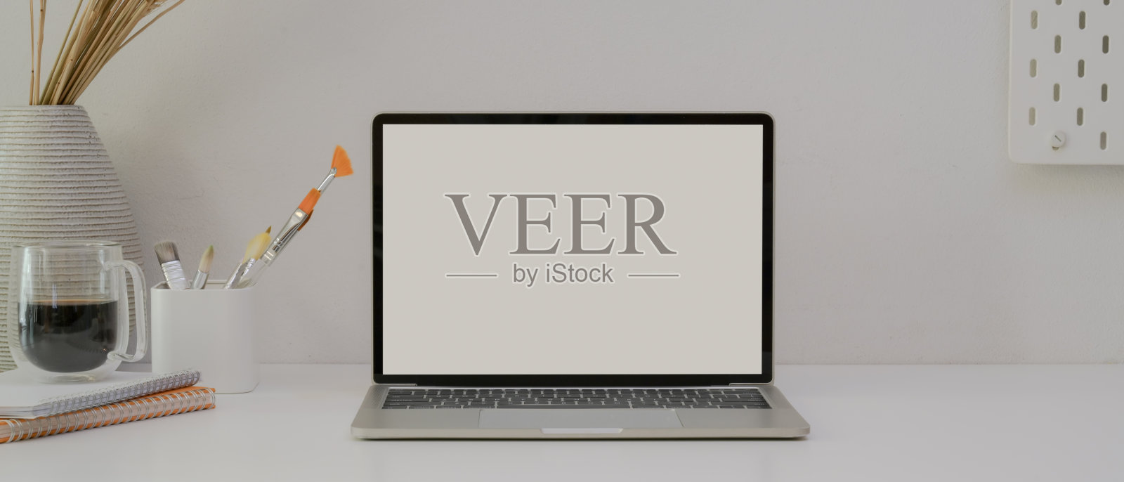 白屏笔记本电脑放在白色办公桌上，配有画笔、咖啡杯、日程表和装饰品照片摄影图片