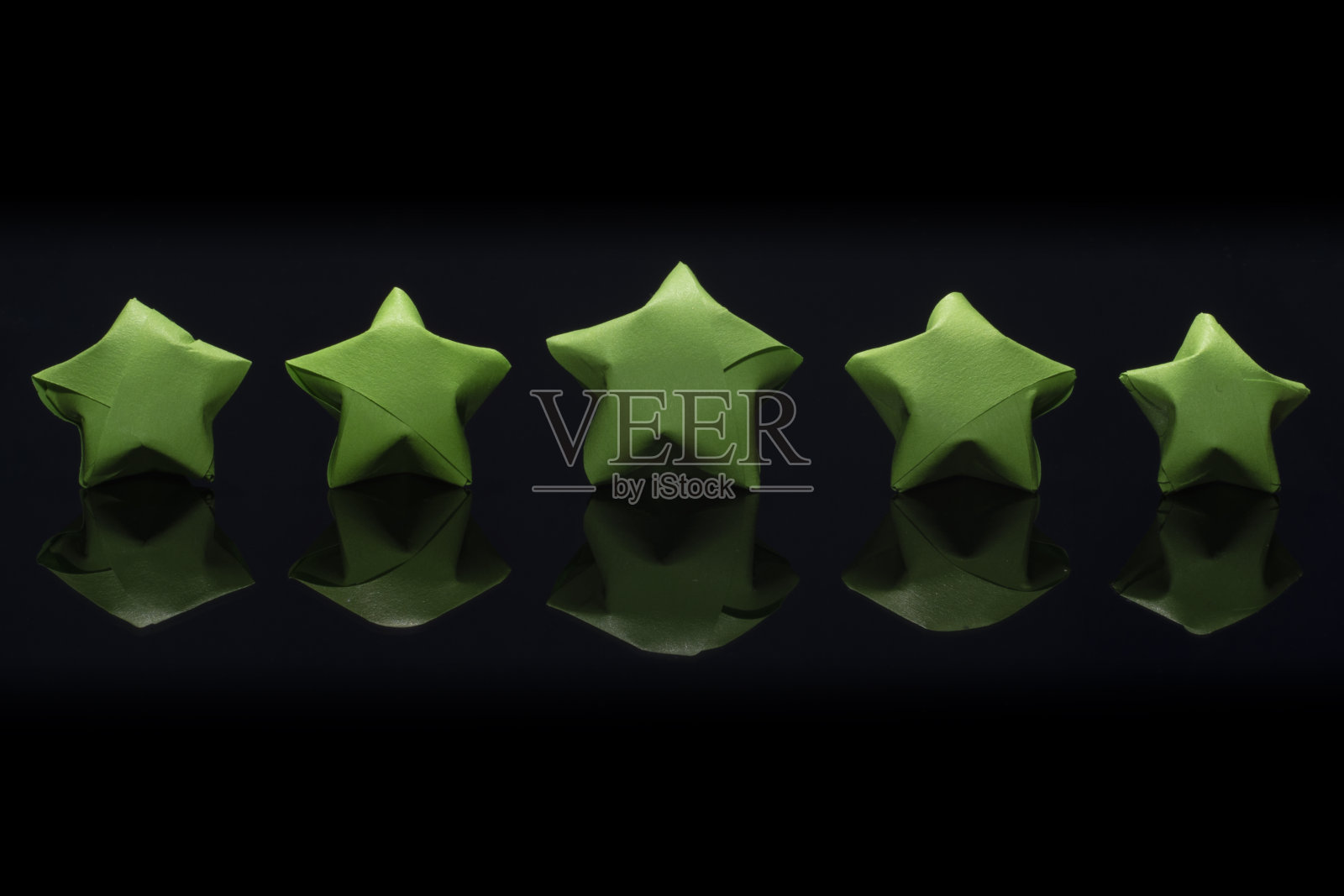 一个空白来展示五颗绿纸星的评级和对黑色背景的反射照片摄影图片