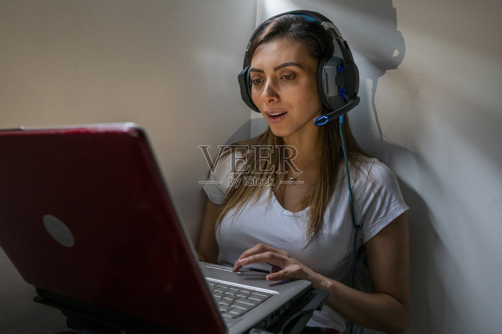 这位年轻的女商人坐在房间的角落边打视频电话边工作照片摄影图片