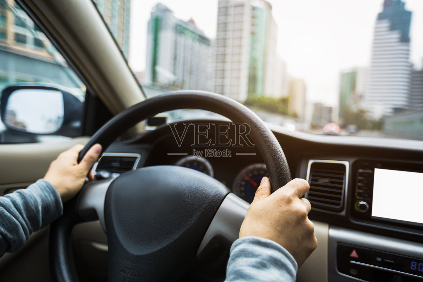 在城市道路上开车时，手握方向盘照片摄影图片