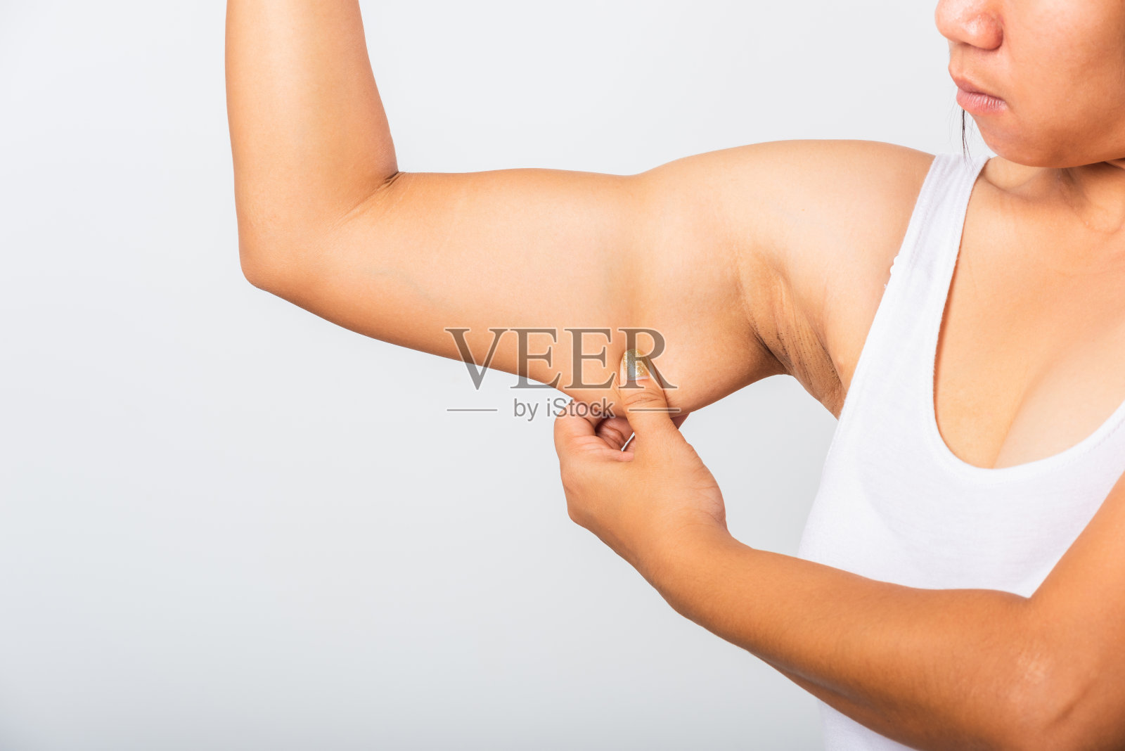 近距离的亚洲妇女拉过量的脂肪在她的腋下，问题腋下皮肤，工作室孤立的白色背景，健康超重过剩的身体概念照片摄影图片