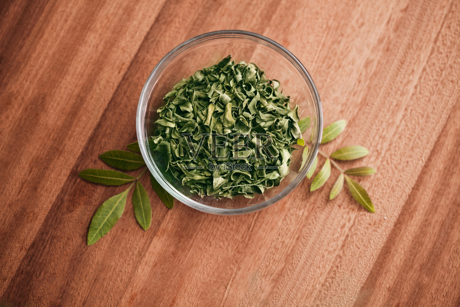辣木叶粉和干燥的叶子在玻璃罐上的背景与复制空间照片摄影图片