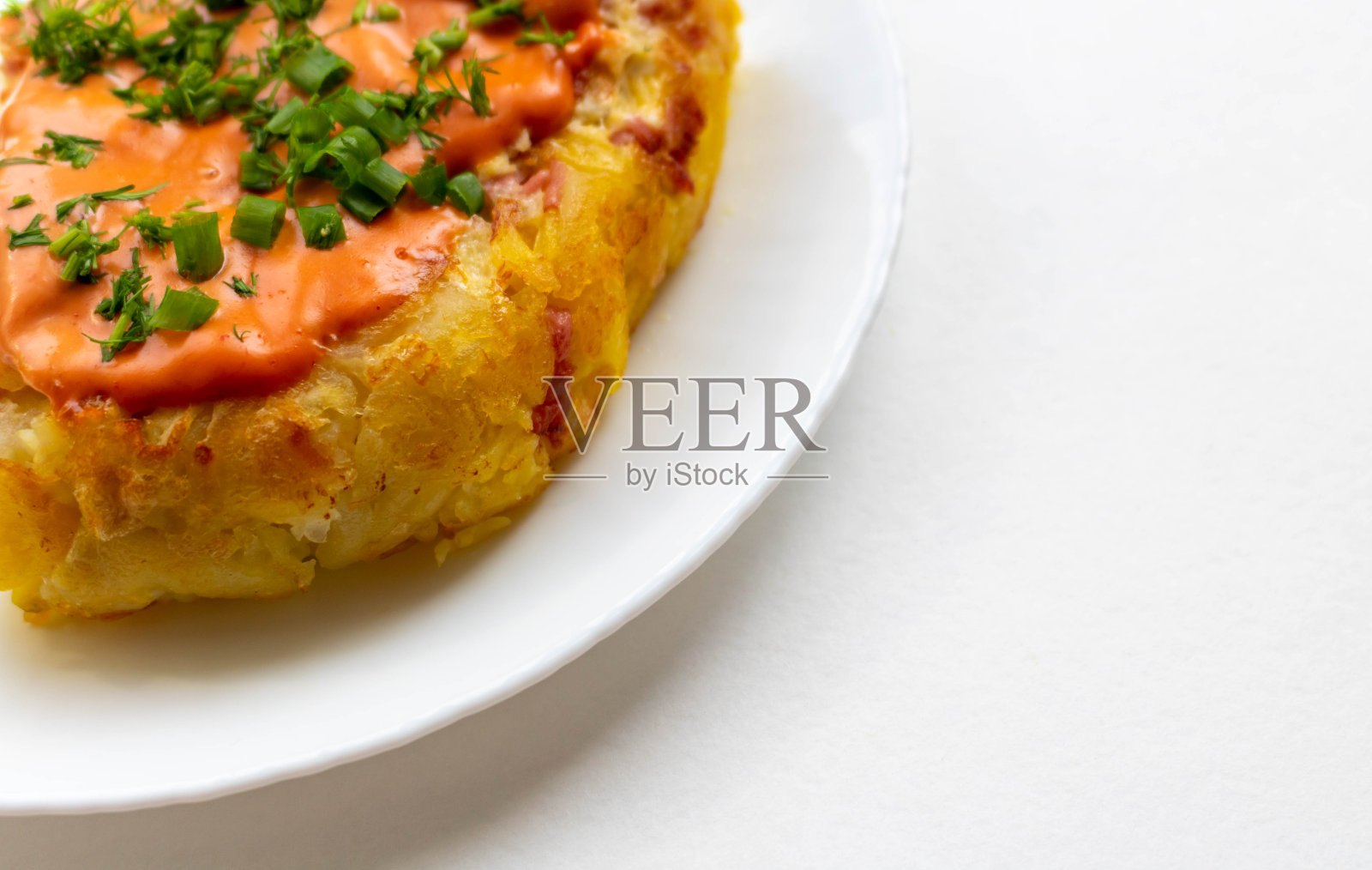 一份配酱汁和香草的土豆砂锅，放在白色盘子里照片摄影图片