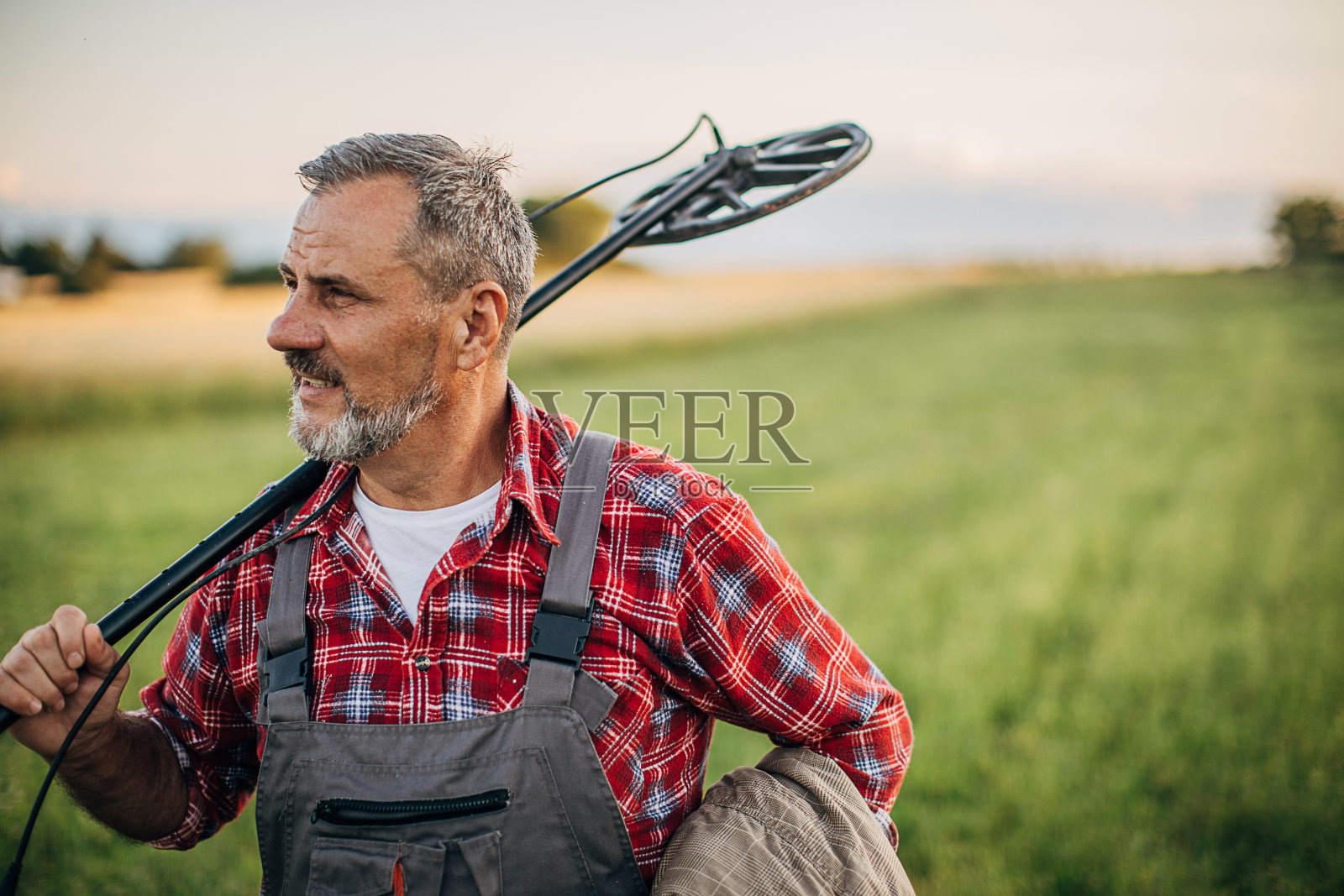 一个带着金属探测器在大自然中寻宝的人照片摄影图片