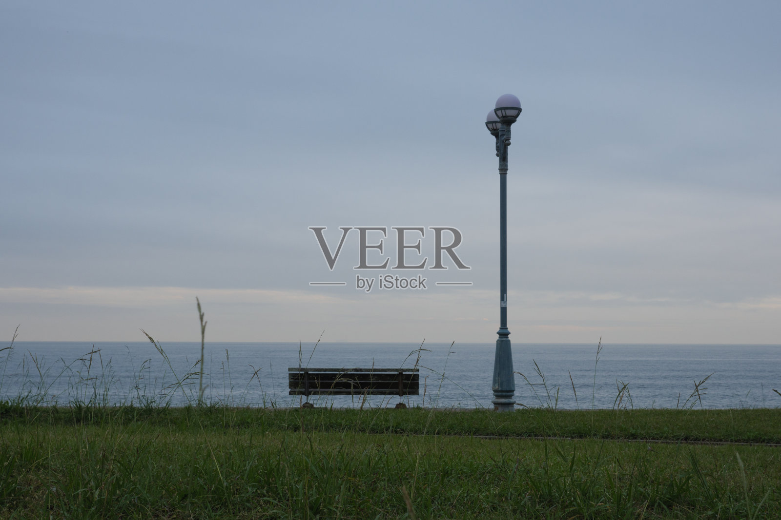 公园长椅和面向大海的户外灯具照片摄影图片