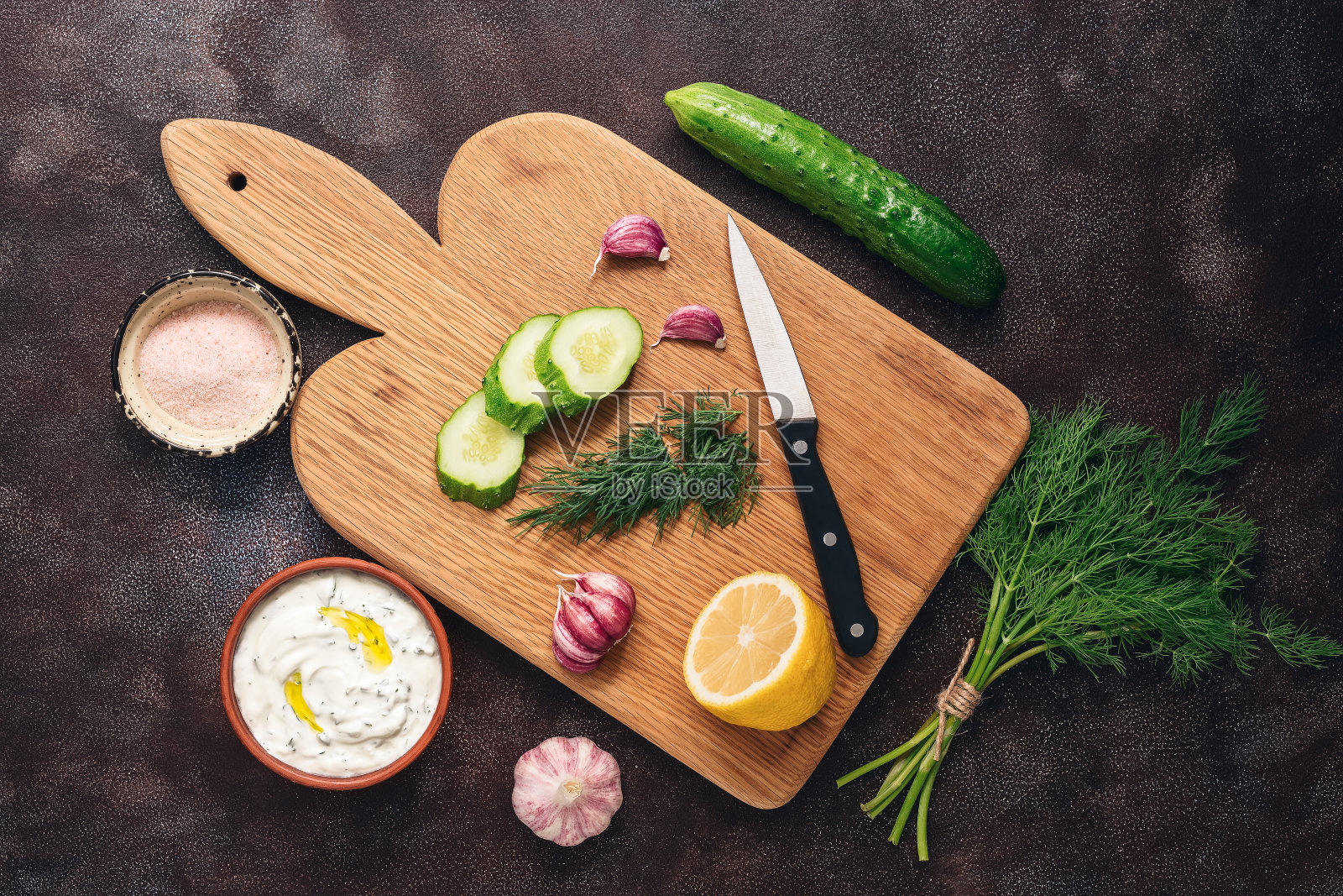 传统的希腊酸奶黄瓜酱配以黑色的乡村背景。加黄瓜、莳萝、大蒜和柠檬的希腊酸奶。俯视图，复制空间，平放。照片摄影图片